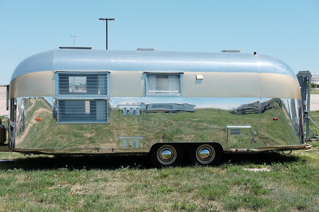 vintage Airstream RV and Camper model trailer parked on the grass at an event