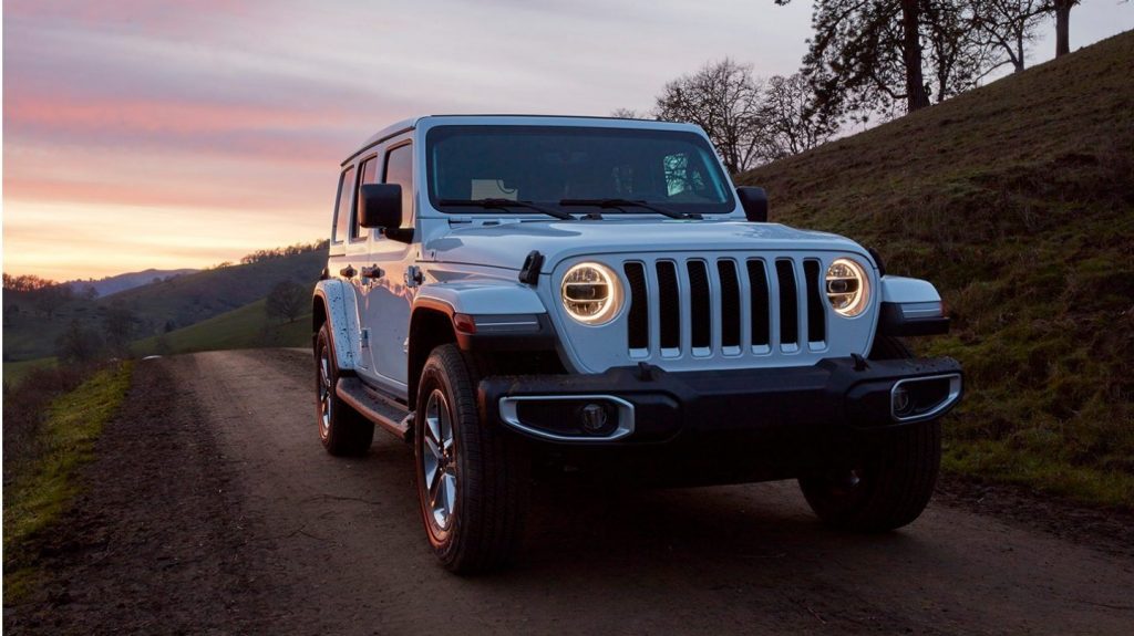 2020 Jeep Wrangler driving at night with its lights on 