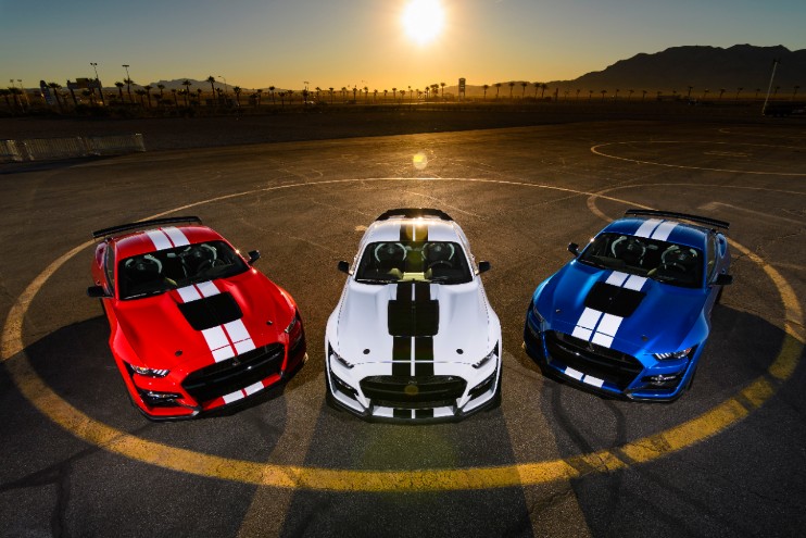 Three Ford Mustangs at sunset