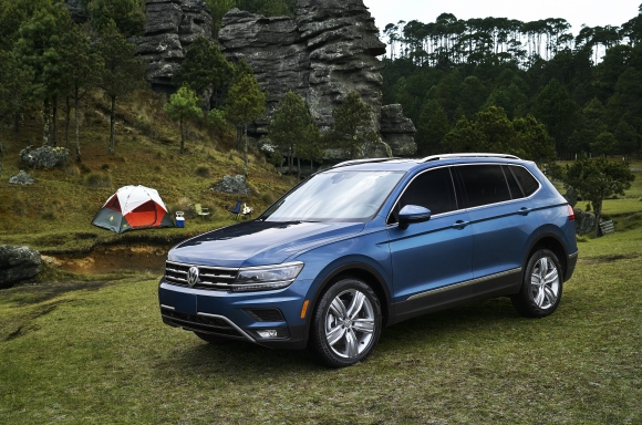 A blue 2020 Volkswagen Tiguan parked ion a grass lot.