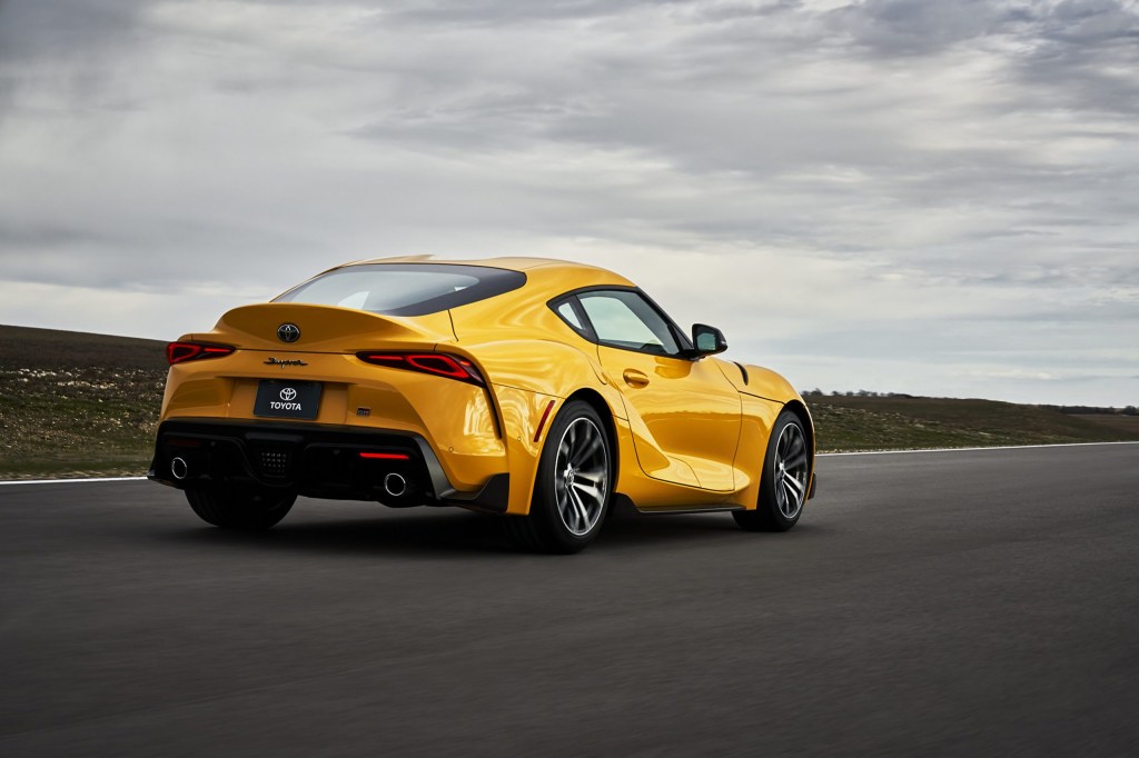 The rear view of a yellow 2021 Toyota Supra 2.0 on a racetrack