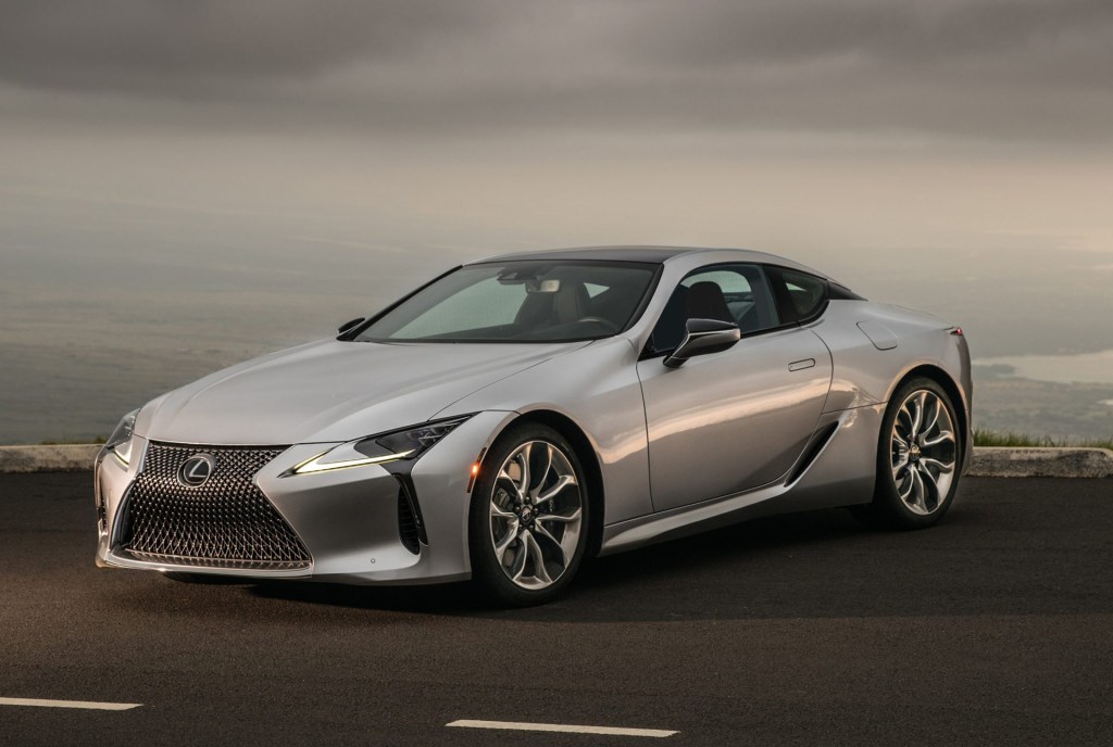 a silver Lexus LC 500 parked on a seaside road exemplifies ultimate luxury