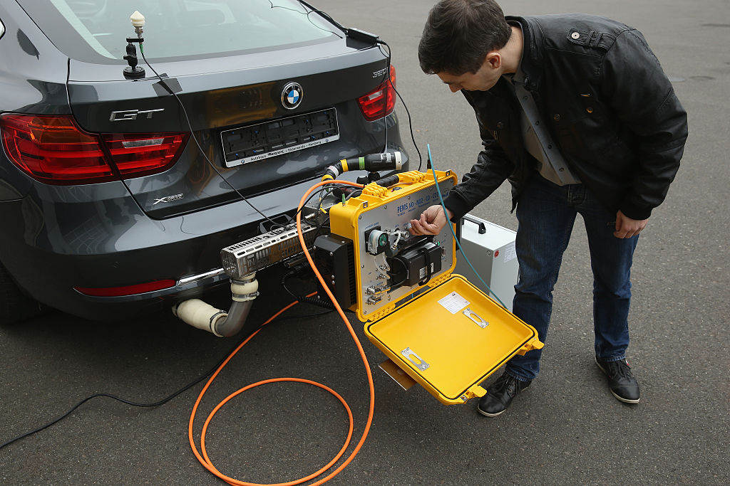A man performs an emissions test on a car
