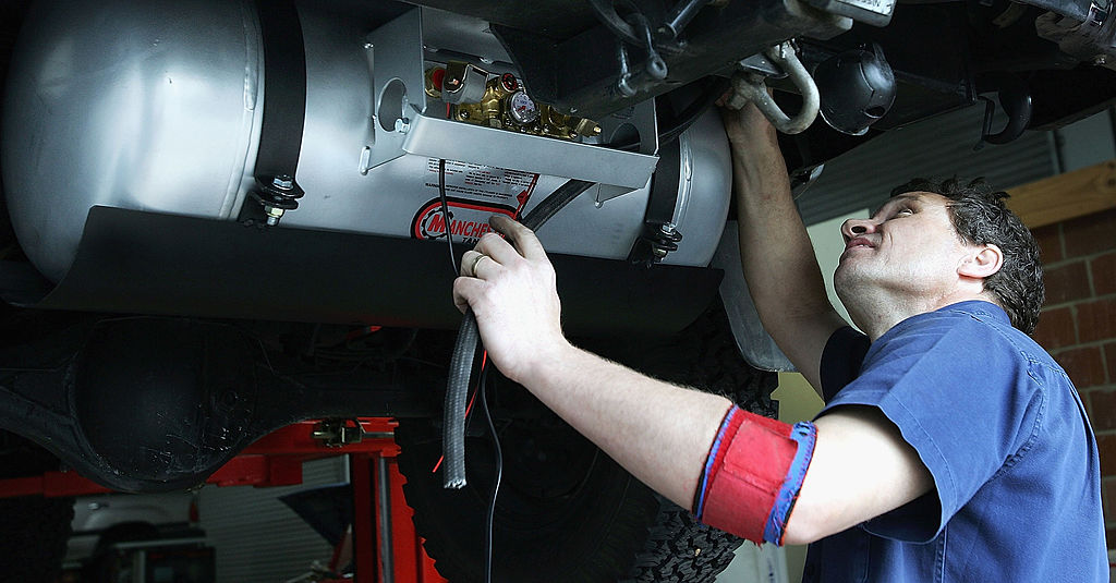 A mechanic prepares to complete an oil change on a car