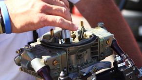A NASCAR Official inspects a carburetor