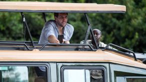 Dirk Nowitzki (l), a former basketball player, looks out from a jeep roof during a tour of Nairobi National Park by the delegation of the Federal President Steinmeier