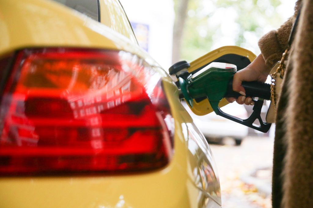 A motorist uses a pump as they re-fuel their car with unleaded petrol