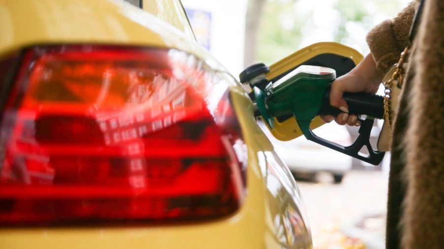 A motorist uses a pump as they re-fuel their car with unleaded petrol