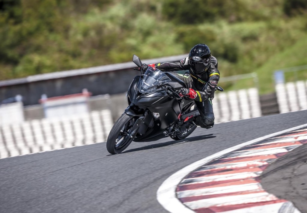 A rider takes the Kawasaki Endeavor manual electric motorcycle prototype around a racetrack
