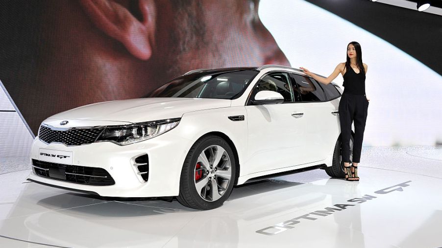 A model poses next to KIA Optima SW GT during the Geneva Motor Show 2016