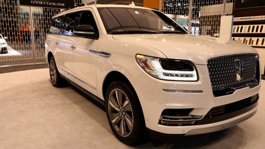 A white Lincoln Navigator on display at an auto show