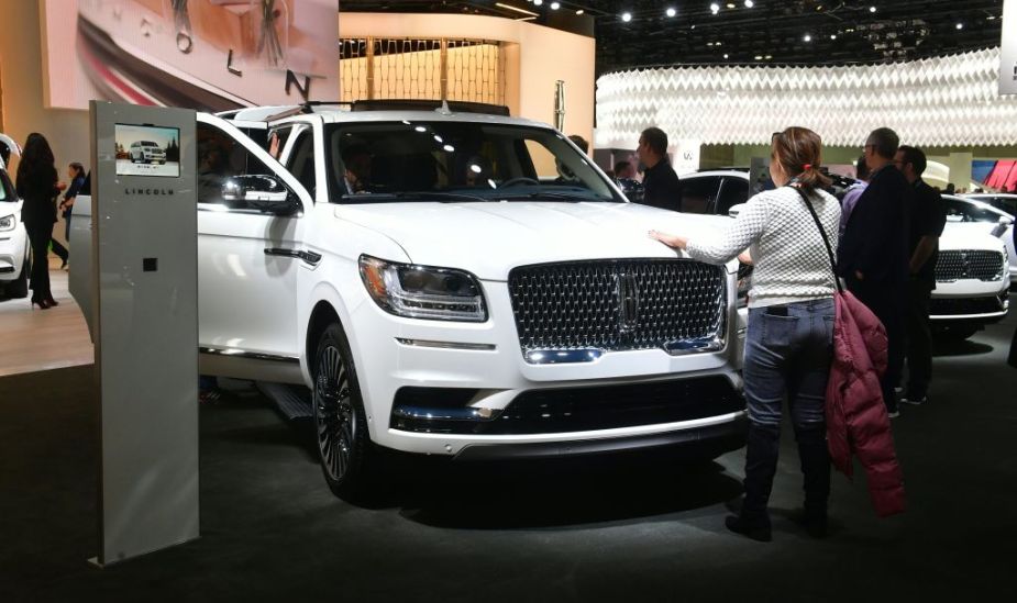 A woman touches the hood of the 2020 Lincoln Navigator L on display at the 2019 Los Angeles Auto Show
