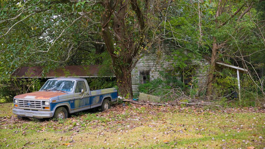 Derelict rundown old Cajun shack and rusty Ford F-150 pick-up truck