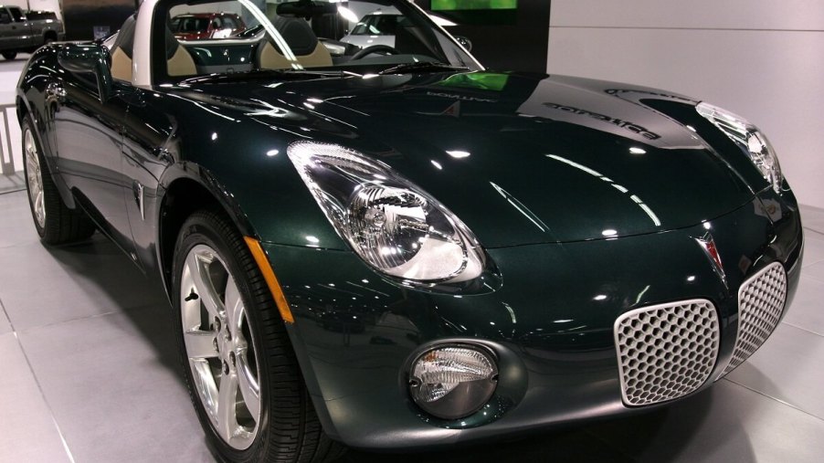 A green Pontiac Solstice parks on a stage.