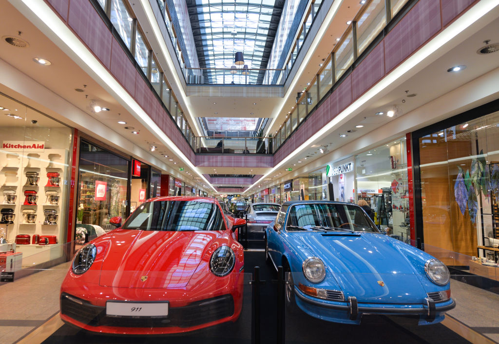 Two Porsche 911 models on display at a car museum
