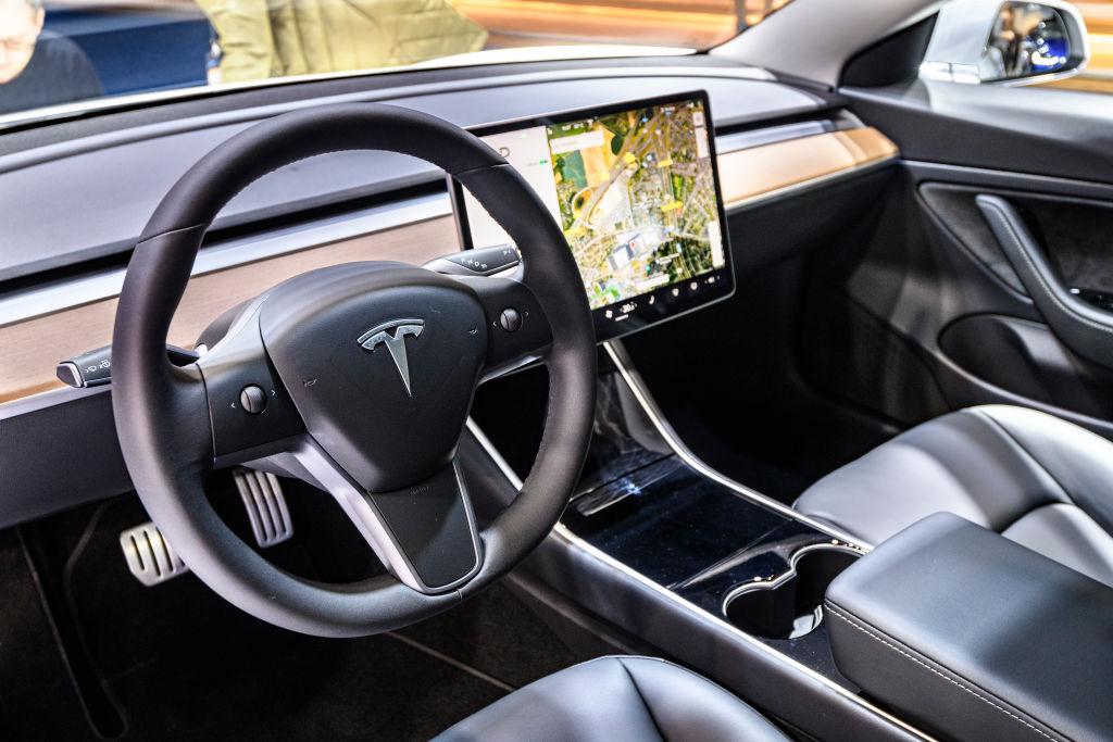 Tesla Model 3 compact full electric car interior with a large touch screen on the dashboard on display at Brussels Expo