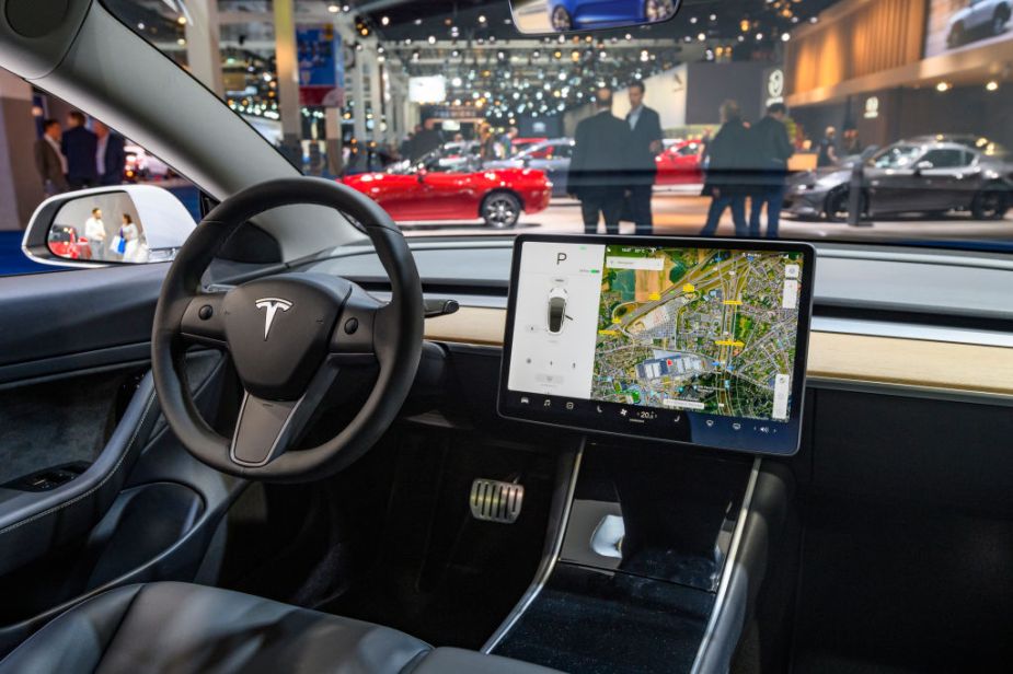 Tesla Model 3 compact full electric car interior with a large touch screen on the dashboard on display at Brussels Expo