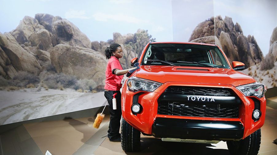 Knatasia Calhoun dusts off a Toyota 4Runner TRD Pro during the media preview at the North American International Auto Show (NAIAS)