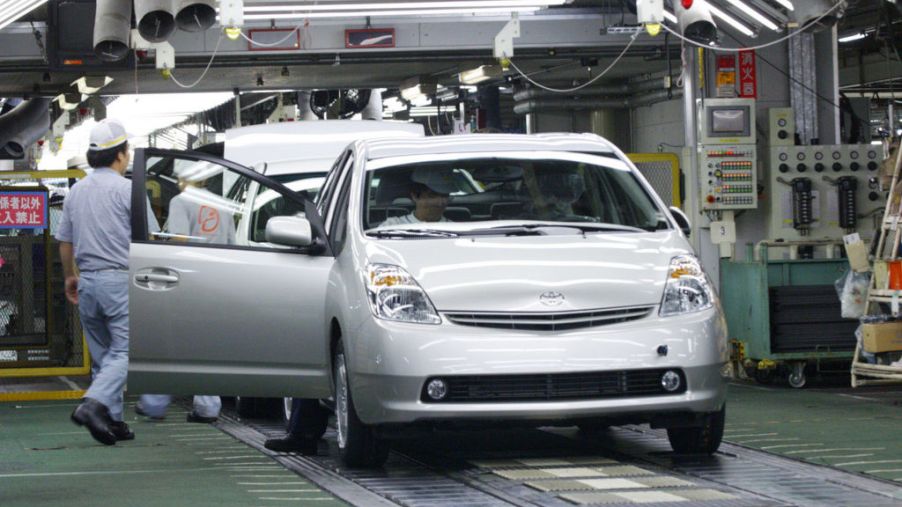 Workers assemble cars at a Toyota production plant