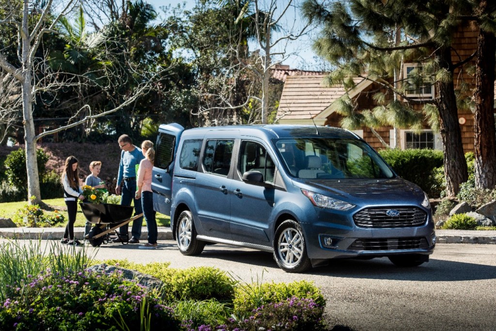 a blue Ford Transit Connect parked in a family driveway