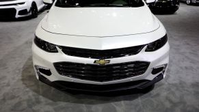 A white Chevy Malibu on display at an auto show