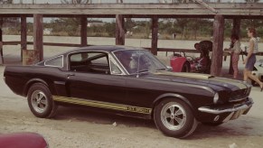 Black-with-gold-stripes 1966 Ford Shelby GT350H Mustang, parked with radio antenna extended