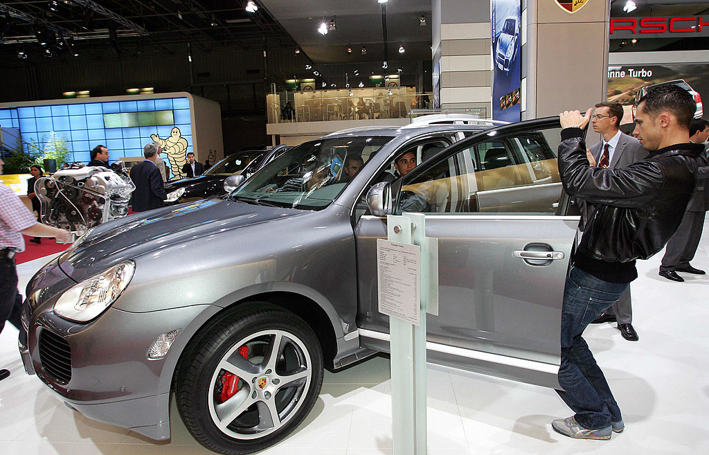 People checking out a Porsche Cayenne at an auto show