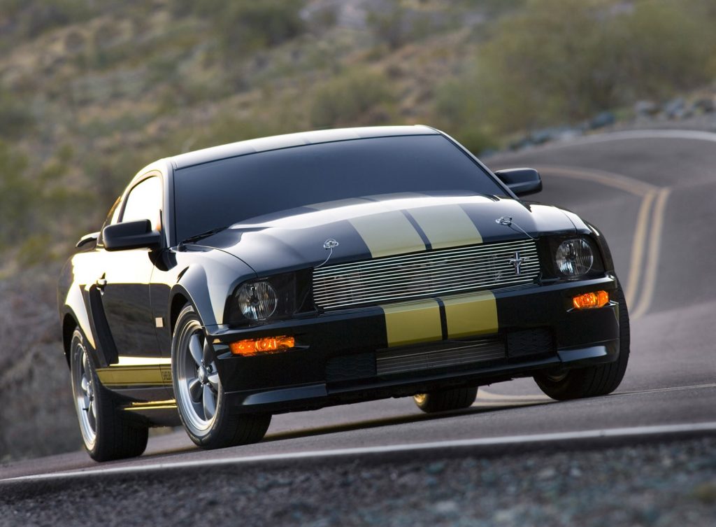 Black-with-gold-stripes 2006 Shelby Mustang GT-H on a curvy desert road