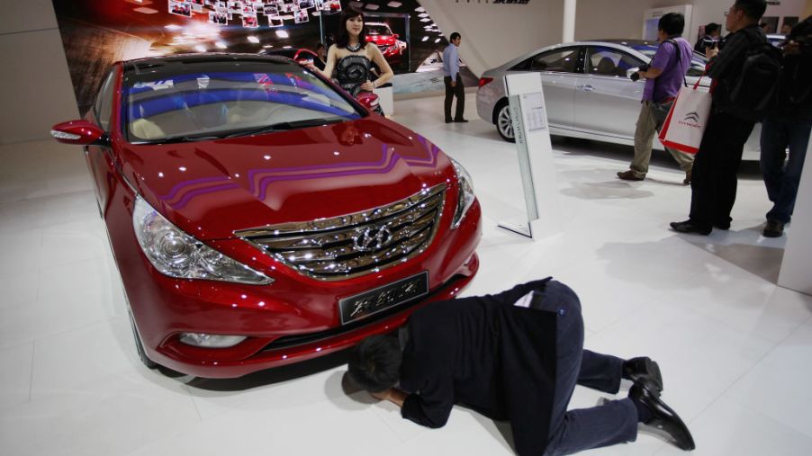 A visitor sees the bottom of a Hyundai Sonata car during the media day of the Shanghai International Automobile Industry Exhibition