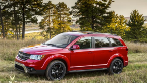 a red Dodge Journey parked in the grass