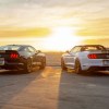 Black-with-gold-stripes 2019 Shelby GT-H Mustang and white-with-gold-stripes Mustang convertible face the sunset