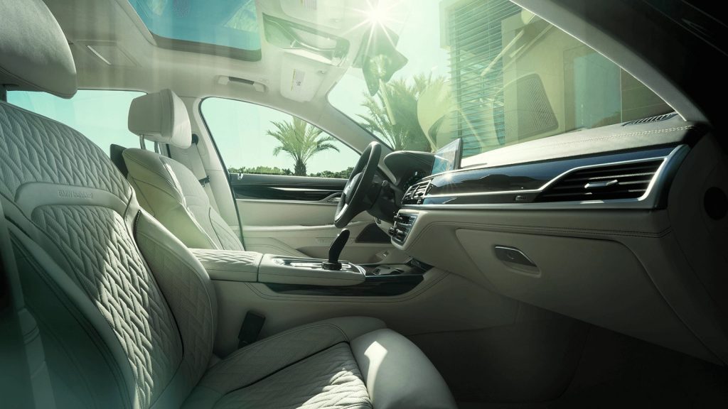 2020 Alpina B7 interior, showing white quilted leather seats and dark wood trim