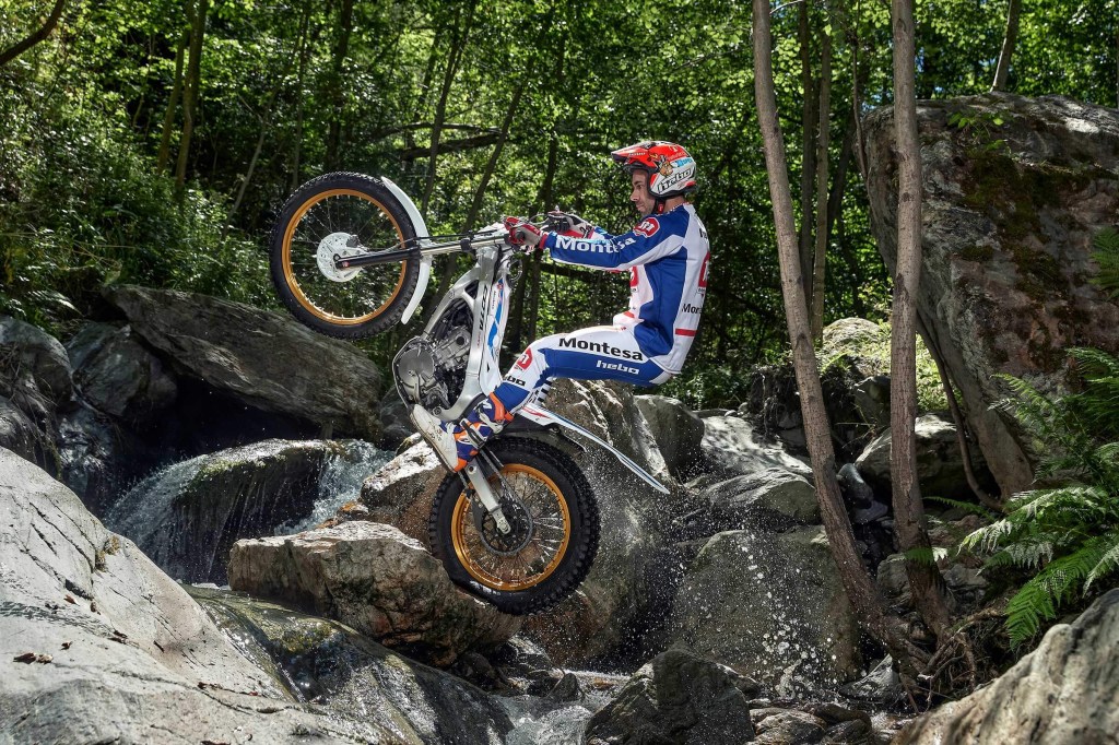 Silver 2020 Honda Montesa Cota 4RT260 jumping over large rocks and flowing stream