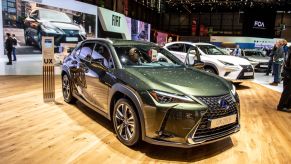 A green Lexus UX on display at an auto show
