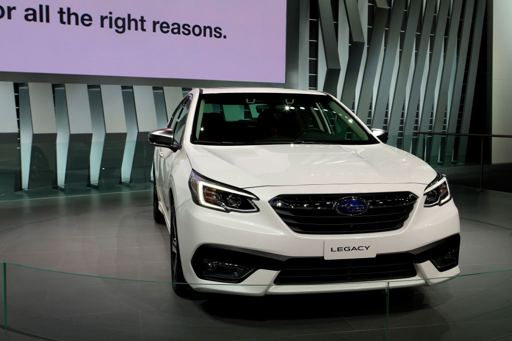 A white Subaru Legacy on display at an auto show, some models have engine problems