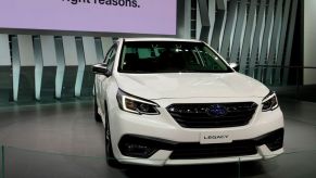 A white Subaru Legacy on display at an auto show