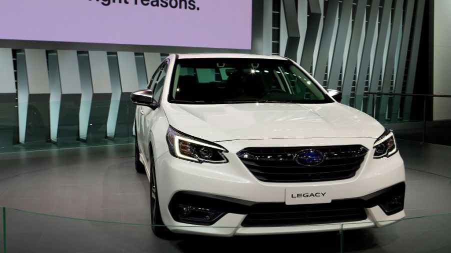 A white Subaru Legacy on display at an auto show