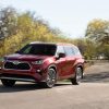 2020 Toyota Highlander Hybrid driving on road in the sun