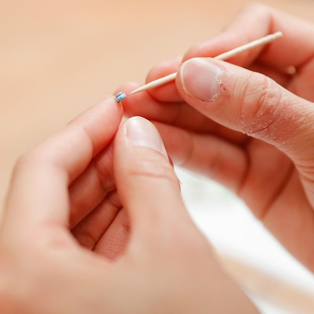 minuscule clay Honda on the end of a pin