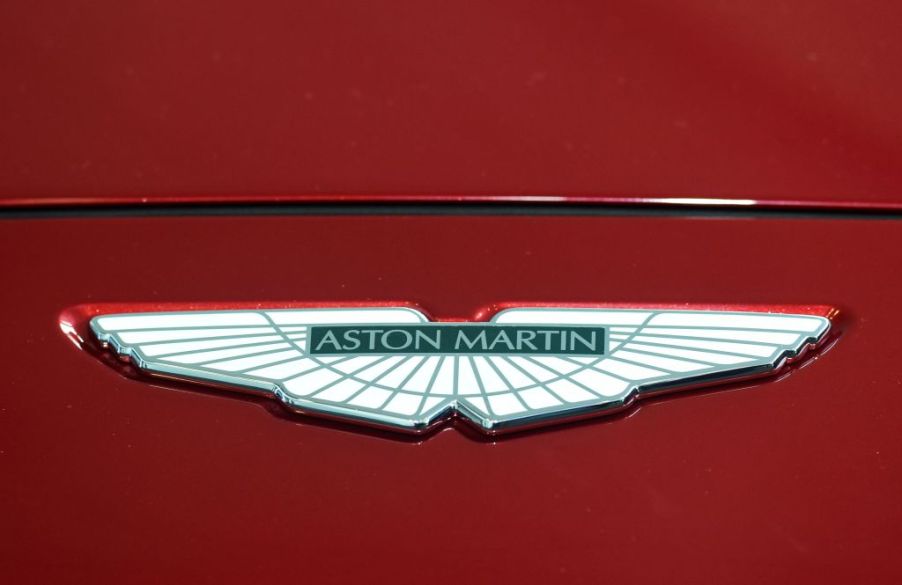 An Aston Marin logo seen on the hood of a red car
