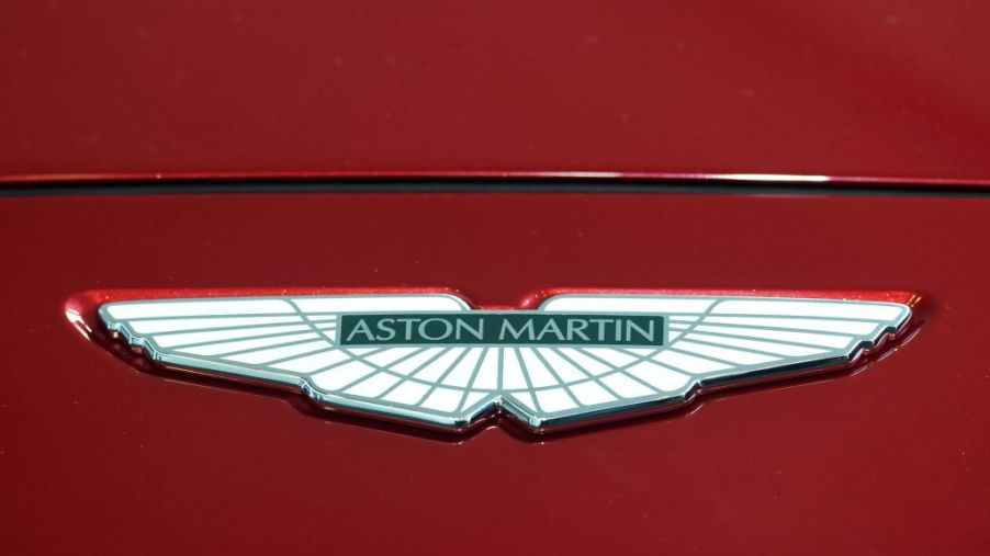 An Aston Marin logo seen on the hood of a red car