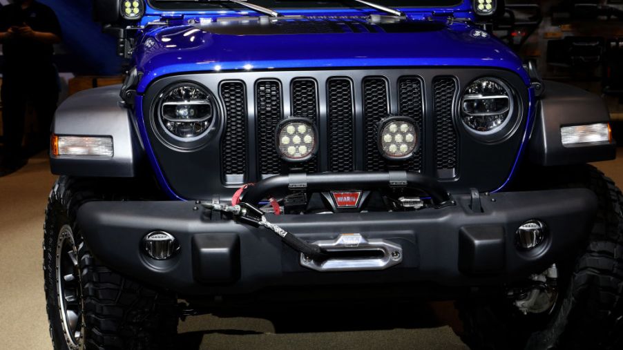 A blue Jeep Wrangler on display at an auto show