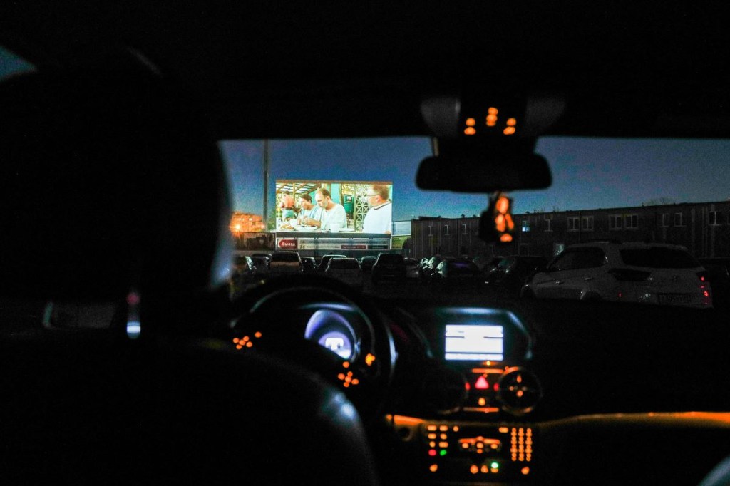 A view of the drive-in screen from inside a car at night