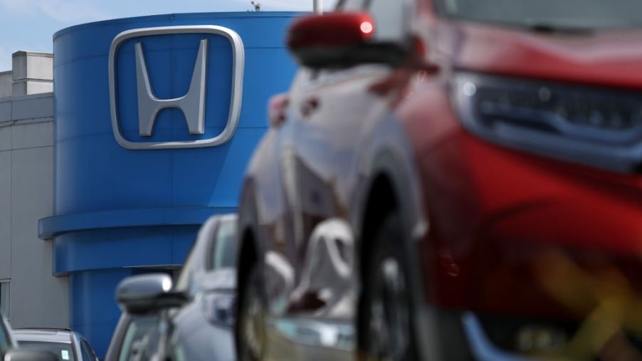 The Honda logo seen in the background of a car dealership