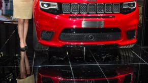 Model poses in front of Jeep Grand Cherokee at the 88th Geneva International Motor Show
