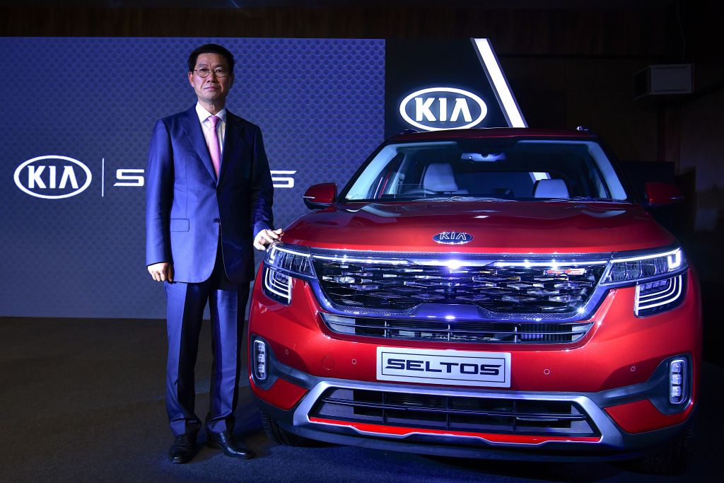 KIA Motors India CEO and managing director Shim Kook-hyun poses with the "Seltos" SUV during the car's launch in Bangalore