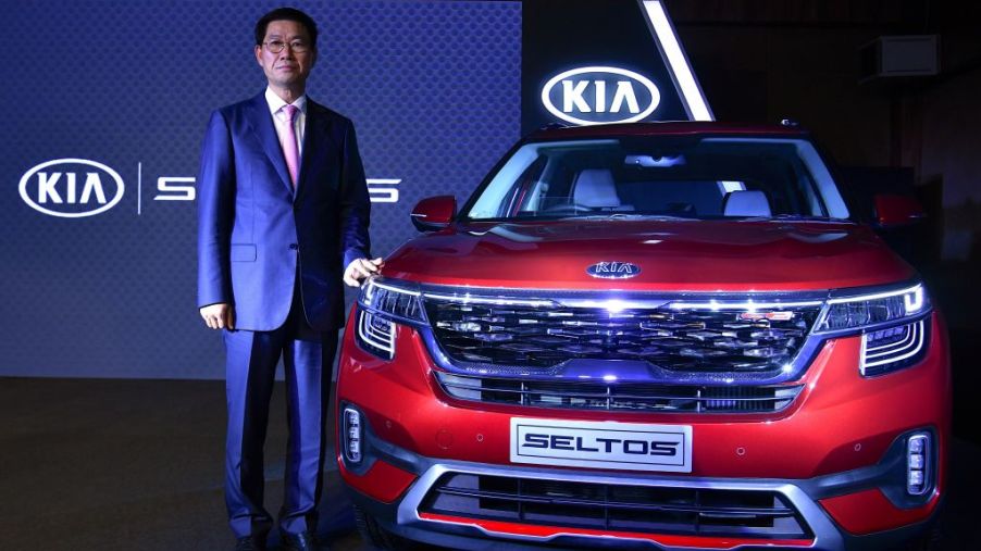 KIA Motors India CEO and managing director Shim Kook-hyun poses with the "Seltos" SUV during the car's launch in Bangalore