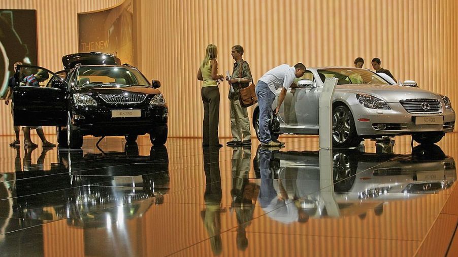 People look at the new Lexus RX350 (L) and Lexus SC430 as they sit on display at the British International Motor Show on July 20, 2006