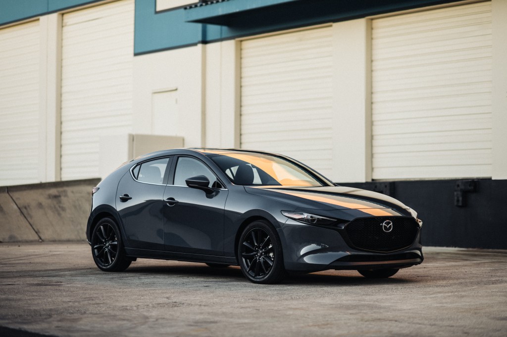 a gray Mazda 3 hatchback parked in an industrial area, which may be getting turbo for 2021