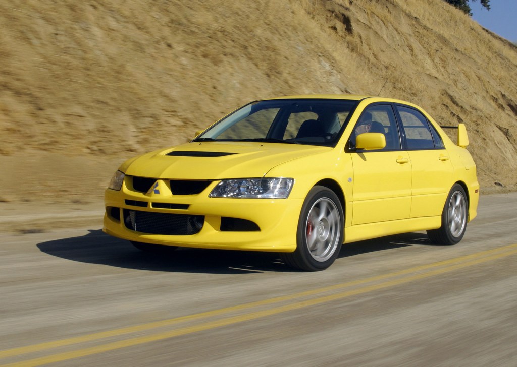yellow Mitsubishi Lancer driving down highway